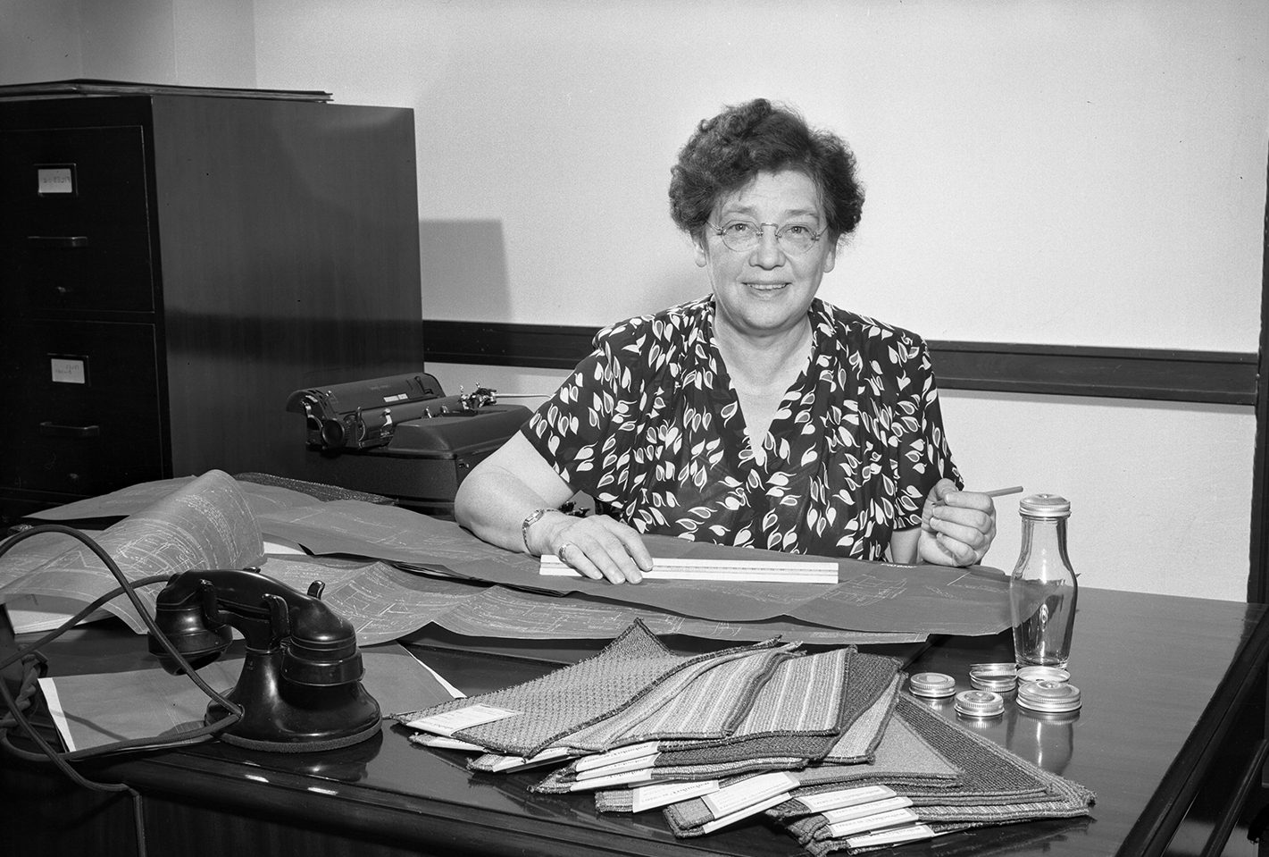 Railroad engineer Olive Dennis, smiling at the camera, sat working behind a desk