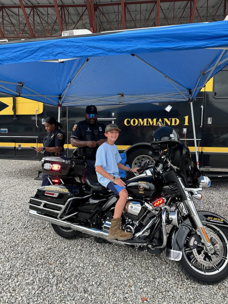 A boy is sitting on a large motorcycle.